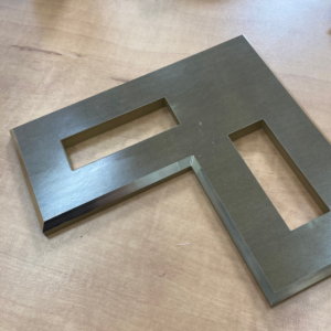 Water Jet cut L-shape in steel plate with through areas.